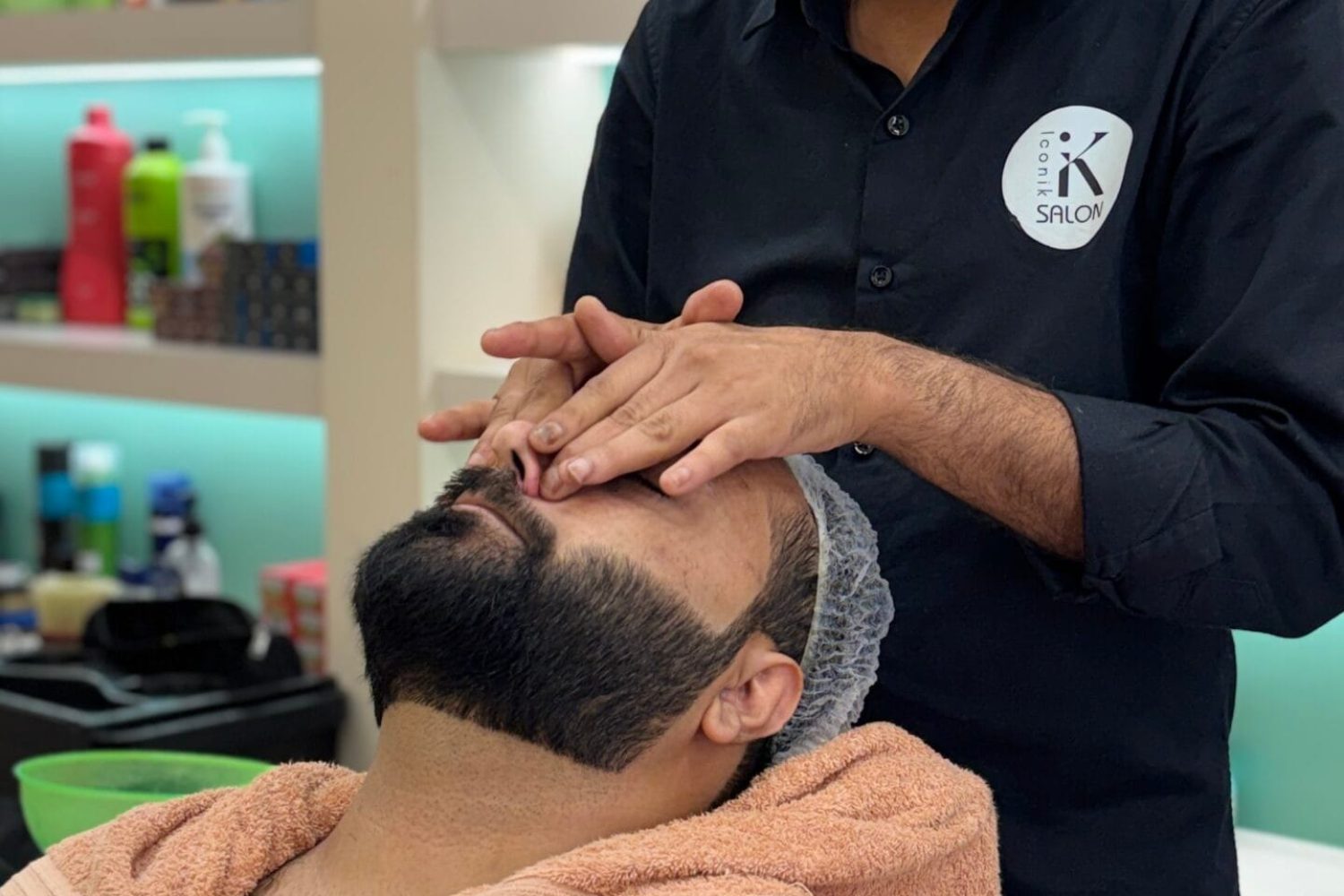 In this picture a face scrub of a male is going on at Iconic salon, one of the best unisex salons in Hisar.