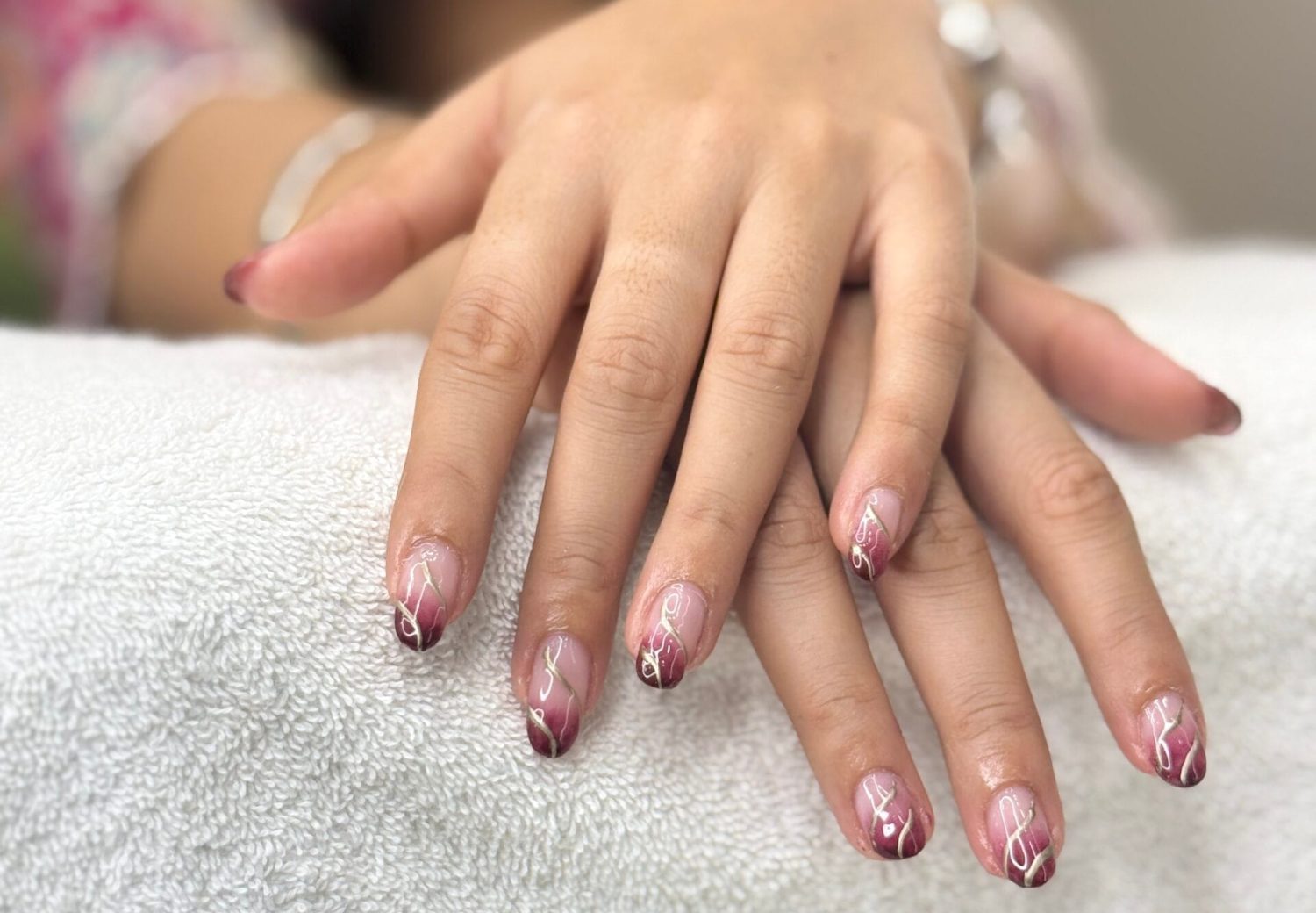 This is the picture of a female showing her newly done nails, which feature a beautiful design.